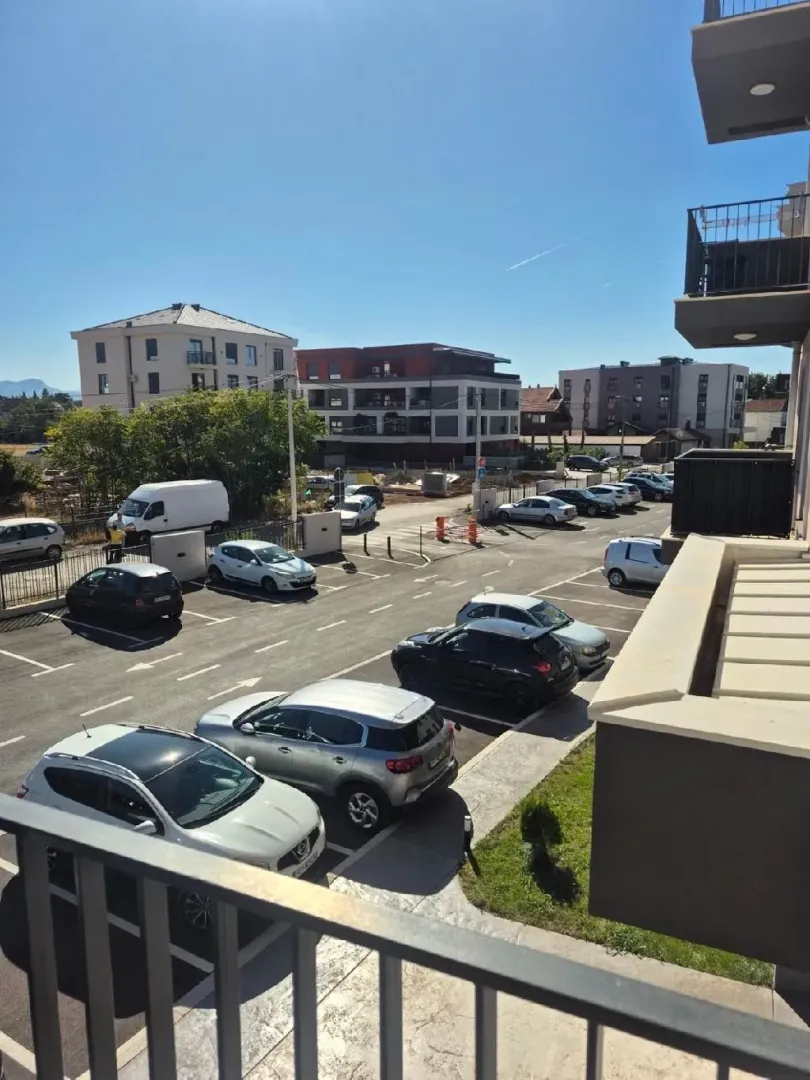 Pogled sa terase na parking prostor i okolne zgrade.