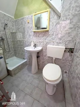 Kupatilo obloženo pločicama sa tuš kabinom, umivaonikom i toaletom. - image 9