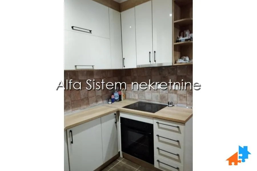 Small kitchen with white cabinets and a built-in oven.