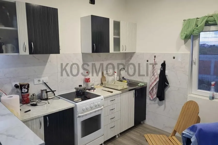 Smaller kitchen with white and dark cabinets and a stove.