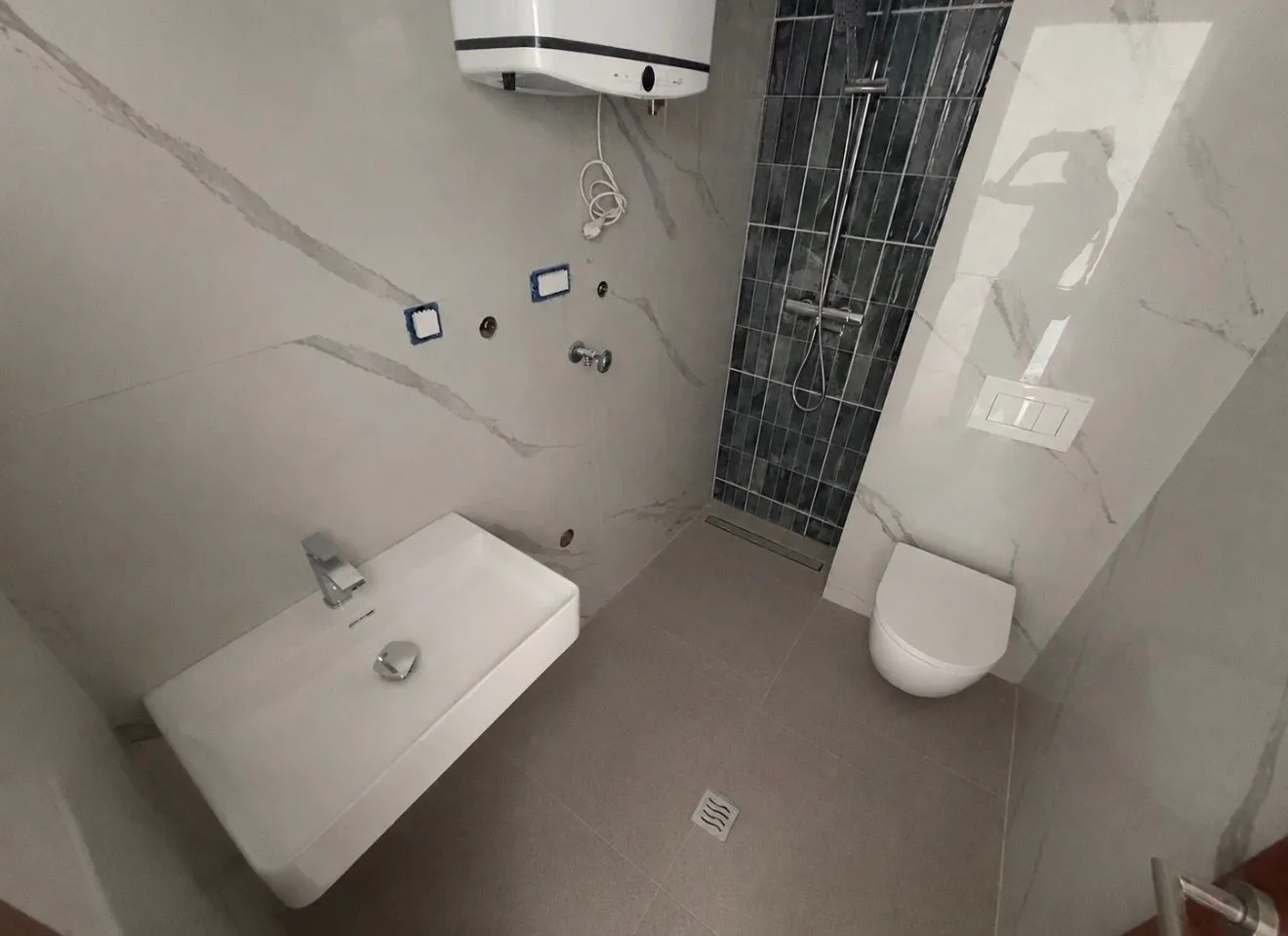 Novoopremljeno kupatilo sa umivaonikom, WC šoljom i tuš kabinom.