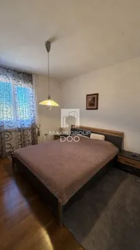 Spavaća soba sa bračnim krevetom, noćnim stočićima i prozorom sa zavesama. - image 11