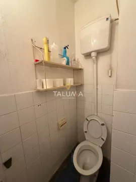 Manje kupatilo sa toaletom i police sa sredstvima za higijenu. - image 13