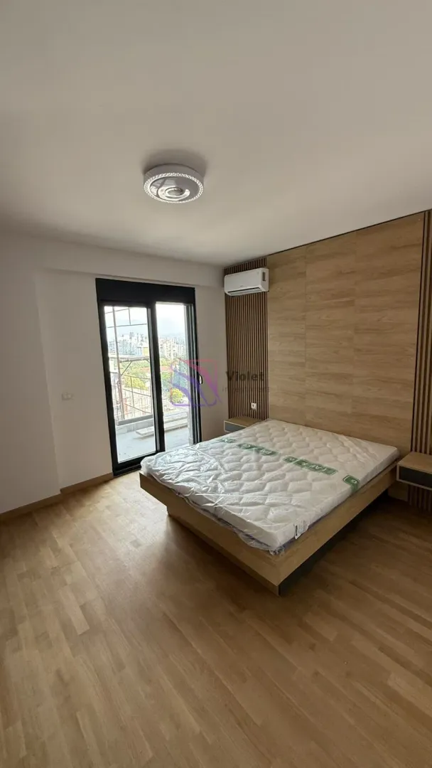 Spavaća soba sa bračnim krevetom i izlazom na terasu.