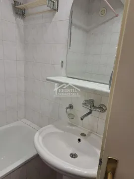 Small bathroom with a washbasin, mirror and bathtub tiled with ceramic tiles. - image 8