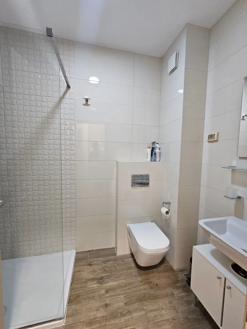 Modernly equipped bathroom with a shower cabin and white sanitary ware.