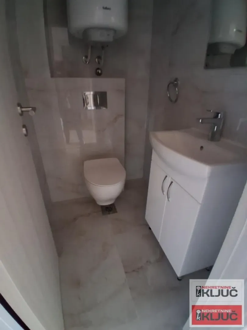 Manje kupatilo sa WC šoljom, umivaonikom i bojlerom.