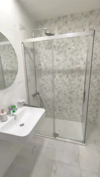 Moderno kupatilo sa staklenom tuš kabinom i bijelim lavaboom. - image 2