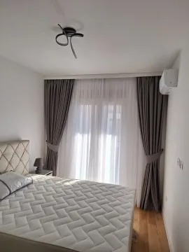 Svijetla spavaća soba sa velikim krevetom i elegantnim zavjesama. - image 10