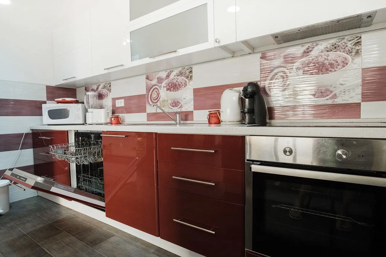 Modern kitchen with white upper and dark red lower cabinets.