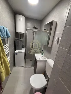 Smaller bathroom with a shower cabin, washbasin, toilet, and water heater. - image 10