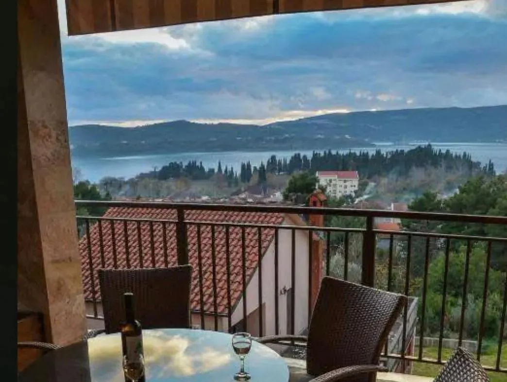 Terasa sa garniturom za sedenje i pogledom na more i brda.