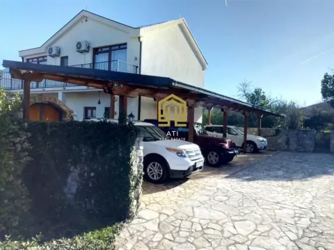 Exterior of the house with a courtyard, covered parking, and parked vehicles. - image 8