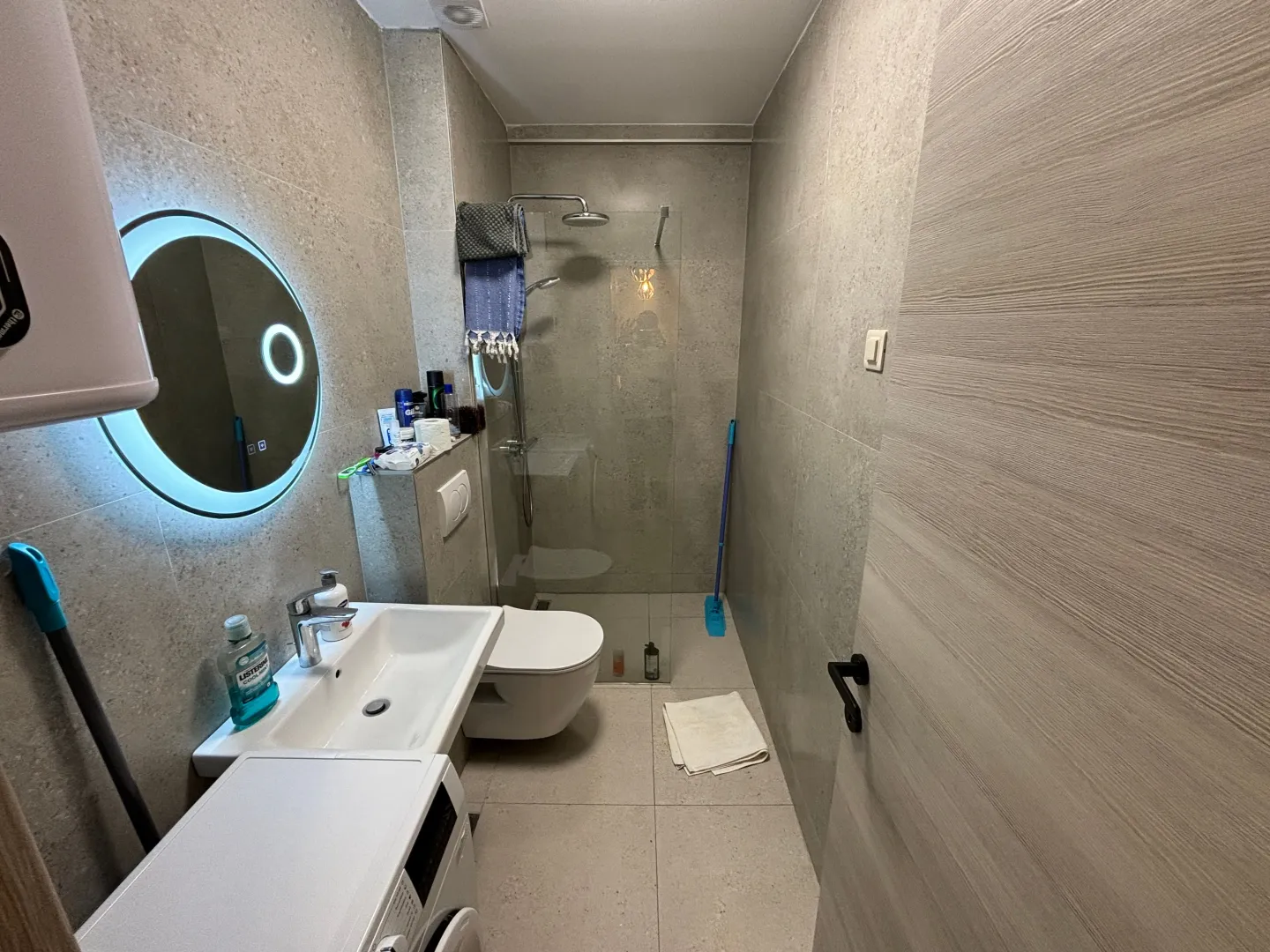 Moderno opremljeno kupatilo sa tuš kabinom, umivaonikom i ugradnom sanitarijom.