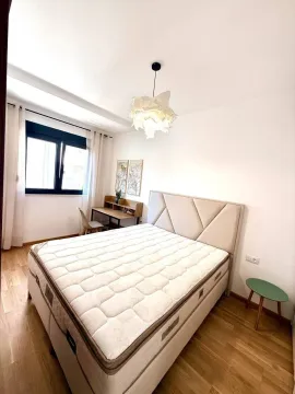 Bright bedroom with a double bed, desk, and a window. - image 4