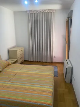 A simply furnished bedroom featuring a large bed and a chest of drawers. - image 11