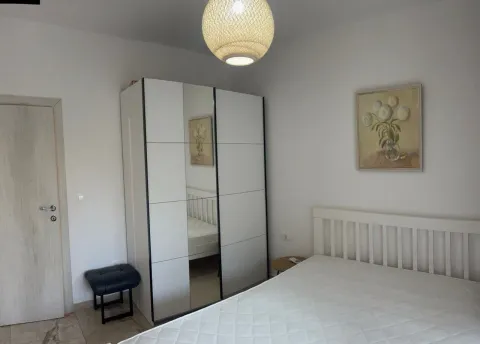 Furnished bedroom with a bed, wardrobe, and a painting on the wall. - image 2