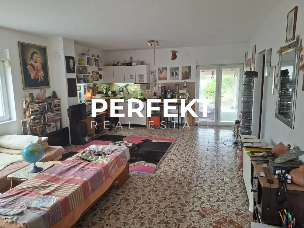Dnevna soba sa prostorom za sedenje i otvorenim delom prema kuhinji.