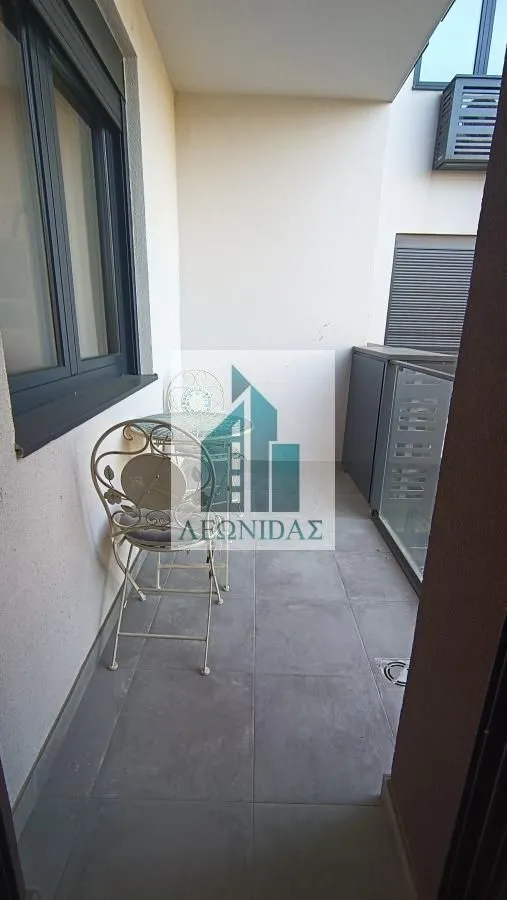 Manji natkriveni balkon sa garniturom za sedenje.