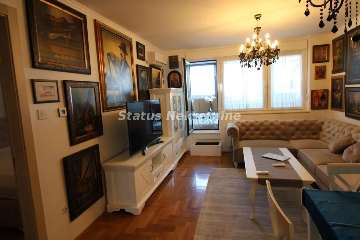 Living room with sofa, TV, and artwork on the walls.