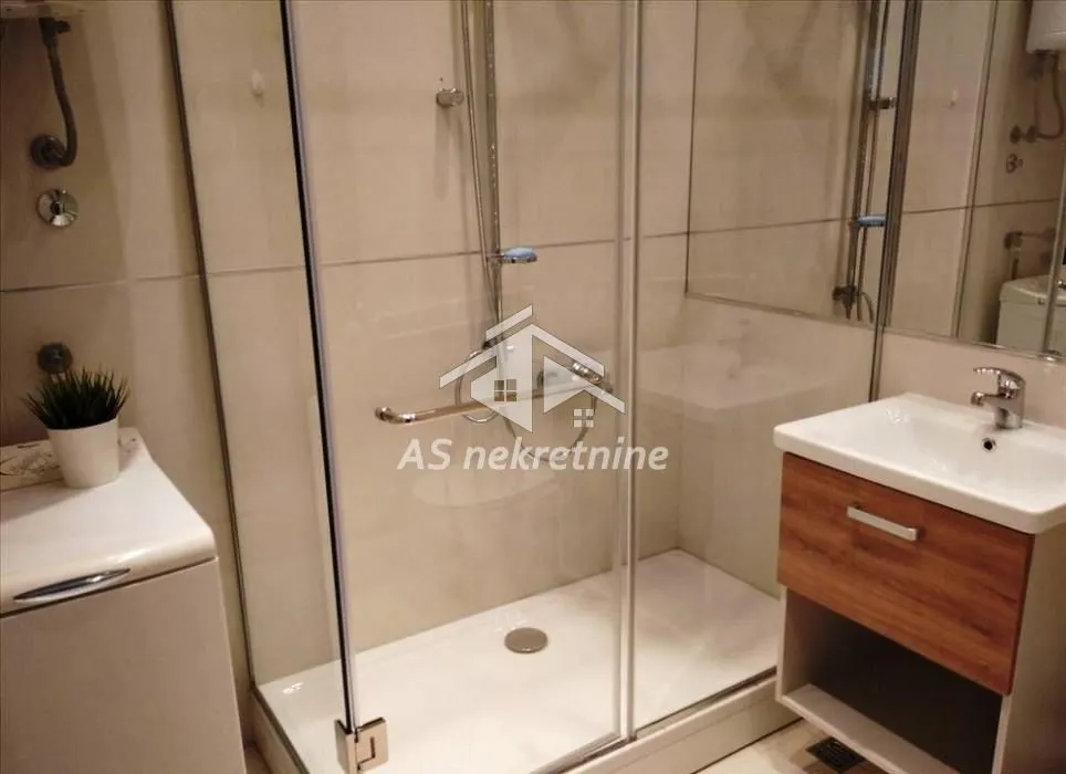 Bathroom equipped with a shower cabin and a vanity unit with a sink.
