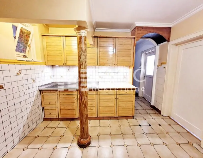 Small kitchen with wooden cabinets and ceramic tiles.