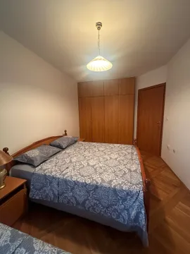 Bedroom with a double bed, wooden wardrobe, and parquet flooring. - image 13