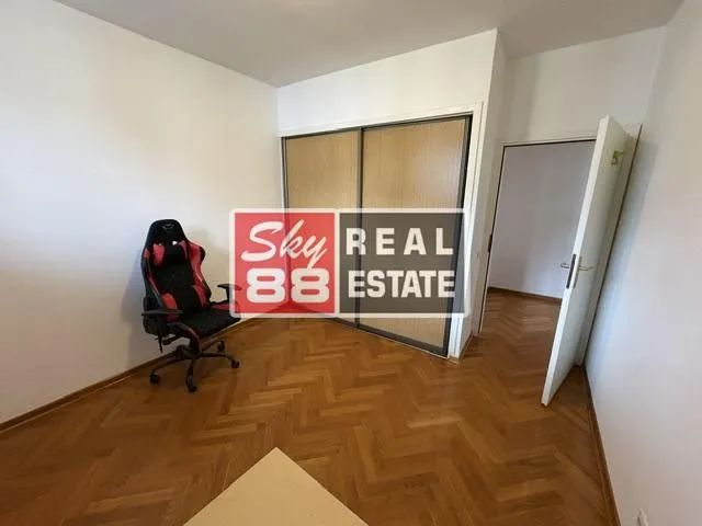 Small room with parquet flooring, built-in wardrobe, and a gaming chair.