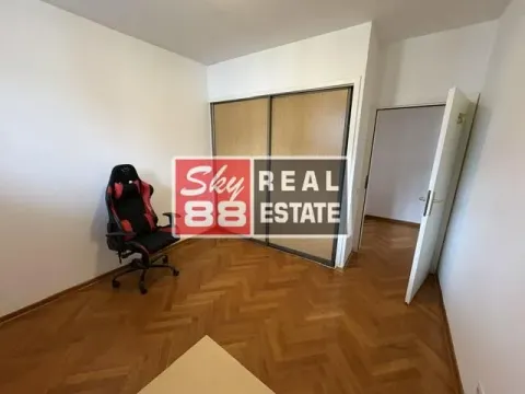 Small room with parquet flooring, built-in wardrobe, and a gaming chair. - image 12