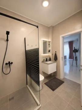 Modernly equipped bathroom with a walk-in shower. - image 5