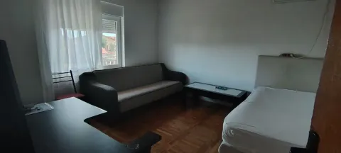 Furnished bedroom with a bed, sofa, and desk. - image 2